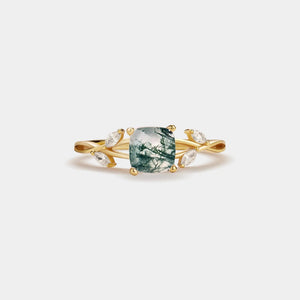 Gold ring with a green gemstone on a white background