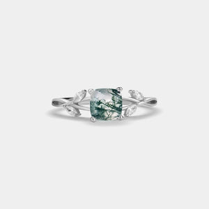 Silver ring with a green gemstone on a white background