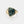 Gold ring with a green stone on a white background