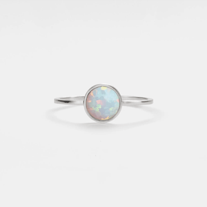 A thin band ring with a hypoallergenic gold plating and a multicolored opal stone in the center.