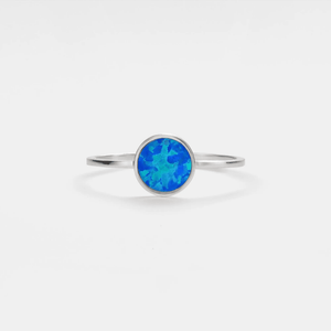 A thin band ring with a hypoallergenic gold plating and a multicolored opal stone in the center.
