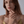 A model wearing a gold bypass ring, featuring a natural opal stone in a thin bypass design.