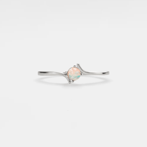 A white gold-plated, solid sterling silver bypass ring with a hypoallergenic finish, featuring a natural opal stone in a thin bypass design.