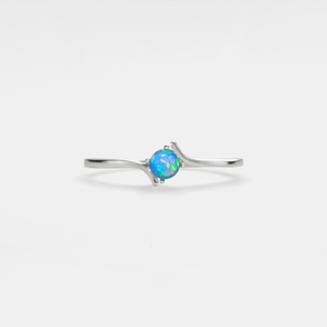 A white gold-plated, solid sterling silver bypass ring with a hypoallergenic finish, featuring a natural opal stone in a thin bypass design.