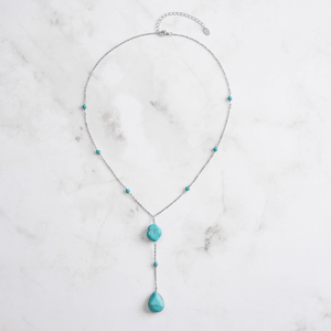 Necklace with turquoise beads on a marble surface