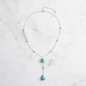 Necklace with turquoise beads on a marble surface