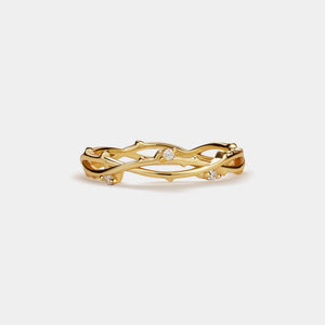 Gold ring with diamond accents on a light beige background