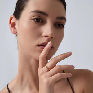 Woman wearing a gold ring on her finger with a neutral background
