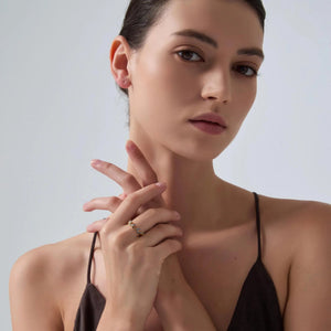 Woman wearing a black strappy top against a plain background
