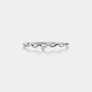 Silver ring with wavy design on a white background