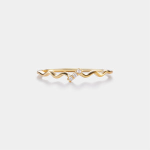 Gold ring with wavy design on a white background