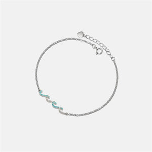 Silver bracelet with turquoise stones on a light gray background