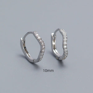 A collection of hoop earrings in various sizes, with some plated in gold and others in silver, all featuring cubic zirconia.
