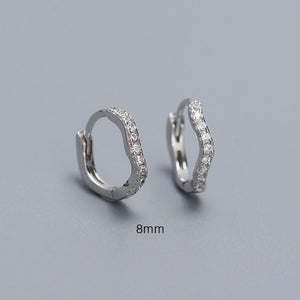 A collection of hoop earrings in various sizes, with some plated in gold and others in silver, all featuring cubic zirconia.
