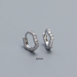 A collection of hoop earrings in various sizes, with some plated in gold and others in silver, all featuring cubic zirconia.