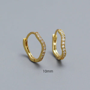 A collection of hoop earrings in various sizes, with some plated in gold and others in silver, all featuring cubic zirconia.