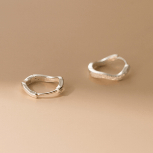Pair of gold hoop earrings on a beige background