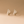 Pair of gold hoop earrings on a beige background