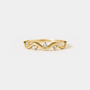 Gold ring with diamond accents on a light gray background