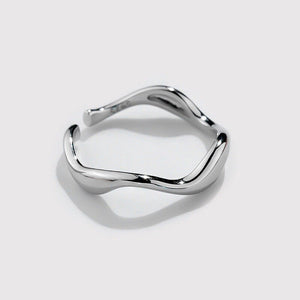 A silver stacking ring with curved wave design, displayed on a plain background.