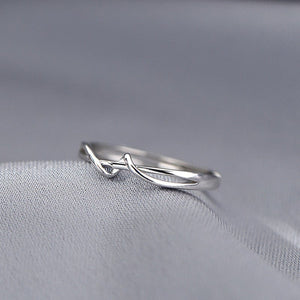 Silver ring with a unique design on a gray fabric background