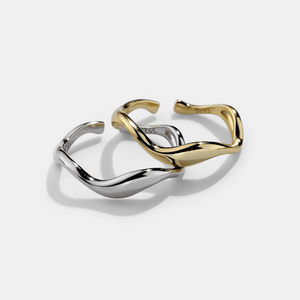 A gold and silver stacking rings with curved wave design, displayed on a plain background.