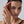 Woman with a gold ring on her finger against a neutral background