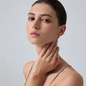Woman touching her neck with a neutral background