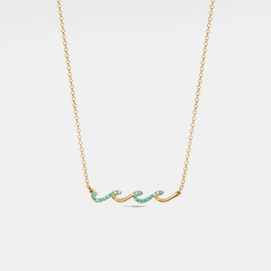 Gold necklace with turquoise stones on a light gray background