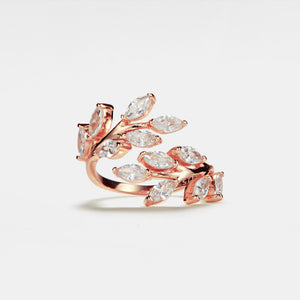 A gold-plated sterling silver cocktail ring with a bypass design featuring clear cubic zirconia stones arranged in an olive leaf pattern on a white background.