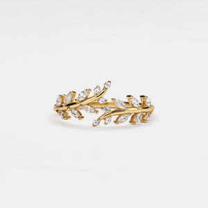 Gold ring with leaf design and clear stones on a white background