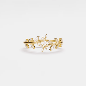 Gold leaf-shaped earring with clear stones on a white background