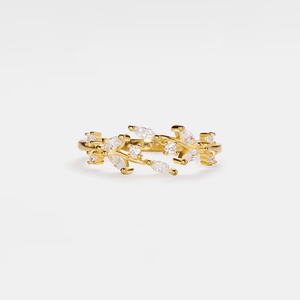 Gold ring with diamond-like stones on a white background