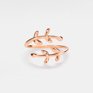 A gold-colored bypass ring with leaf patterns, displayed against a white background.
