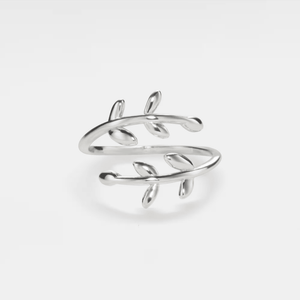 A gold-colored bypass ring with leaf patterns, displayed against a white background.