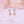 Pair of pearl earrings on a soft pink background