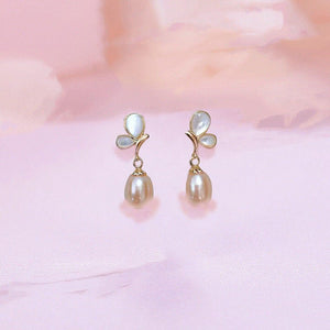 Pair of pearl earrings on a soft pink background