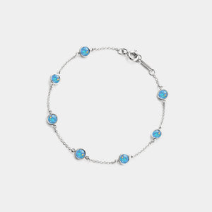 Silver bracelet with blue gemstones on a light gray background