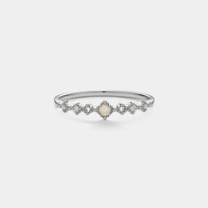 Silver bracelet with a central pearl and diamond-like stones on a light gray background