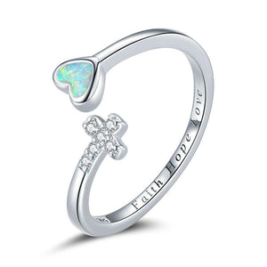 Silver ring with heart-shaped opal and bow design on a white background