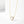 Gold necklace with a heart-shaped opal pendant on a white background