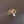 Gold ring with pink gemstone and pearl on a dark fabric background