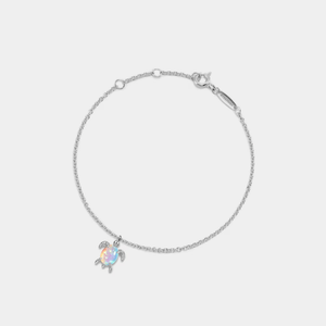 A gold-plated sterling silver bracelet with an opal sea turtle charm, on an adjustable chain.