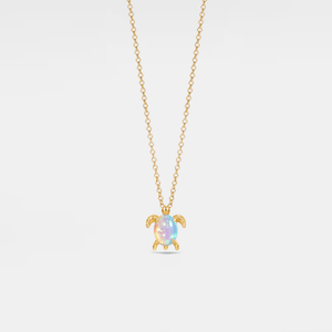 Gold necklace with a turtle-shaped pendant on a light gray background