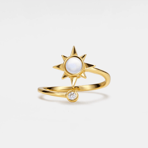 A gold-colored spinner ring featuring a central opal stone with a star design, accompanied by a small cubic zirconia.