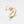 Gold spinner ring with sun design and small gemstone on a light beige background
