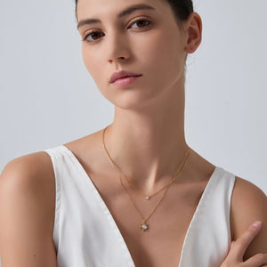 Woman wearing a gold necklace with a white background