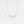 Gold necklace with a delicate pendant on a light gray background