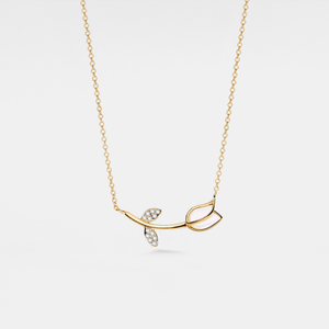 Gold necklace with a delicate pendant on a light gray background