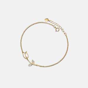 Gold bracelet with a delicate design on a light gray background